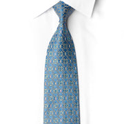 Full-length diagonal view of a blue silk tie featuring a gold-toned geometric lattice and scattered teal and iridescent crystal rhinestones.
