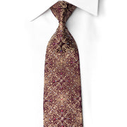 San-Dee burgundy silk rhinestone necktie with gold baroque scroll pattern worn knotted on white shirt — front view