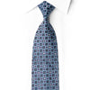 San-Dee midnight navy rhinestone silk tie knotted against a white shirt, showing silver-blue floral motifs and teal and burgundy details.