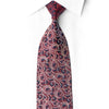 Close-up of a knotted San-Dee crimson and black silk necktie with sparkling crystal rhinestones, worn against a white shirt.