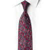 Crimson-red silk necktie knotted against a white shirt, with deep blue-purple scrollwork outlined in sparkling crystal rhinestones.