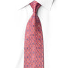 San-Dee coral pink silk necktie knotted on a white shirt, with blue-violet floral geometry and a sparkling crystal rhinestone diamond lattice.